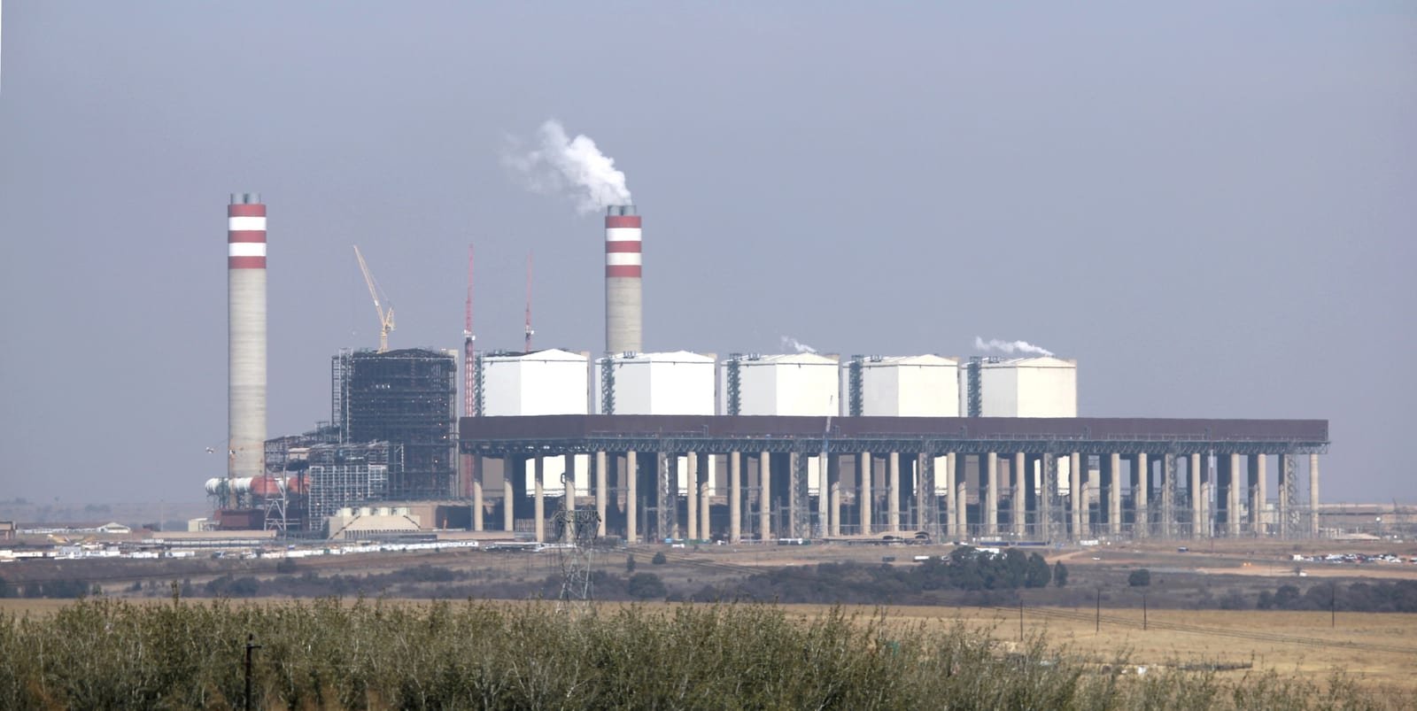 Kusile Power Station in Mpumalanga, South Africa: chimneys and boiler units seen across open fields.